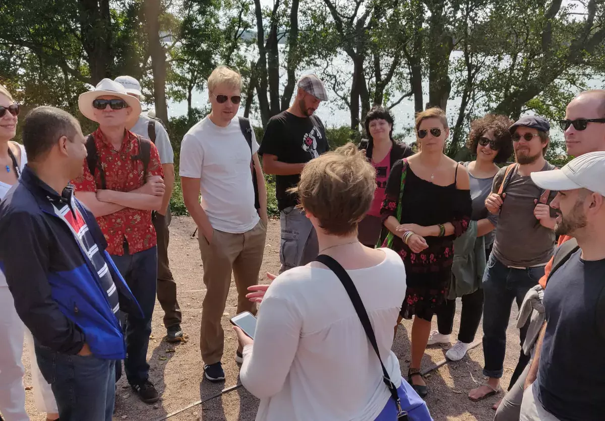 Conference organizer, Sophia Hagolani-Albov introduces the excursion group to Lonna Island where they enjoyed sunshine, sauna, coffee, cake, and conversation.