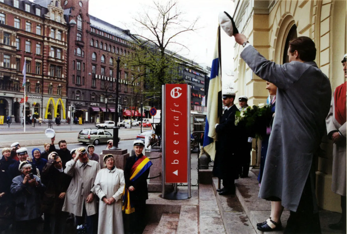 Filosofisen tiedekunnan promootio 2000. Flooranpäivä 13.5., Promootioväkeä Vanhan ylioppilastalon edustalla. Oikealla tervehtii gratisti Tero Halonen. Kuva: Jakke Nikkarinen, Tiedemuseo Liekki.